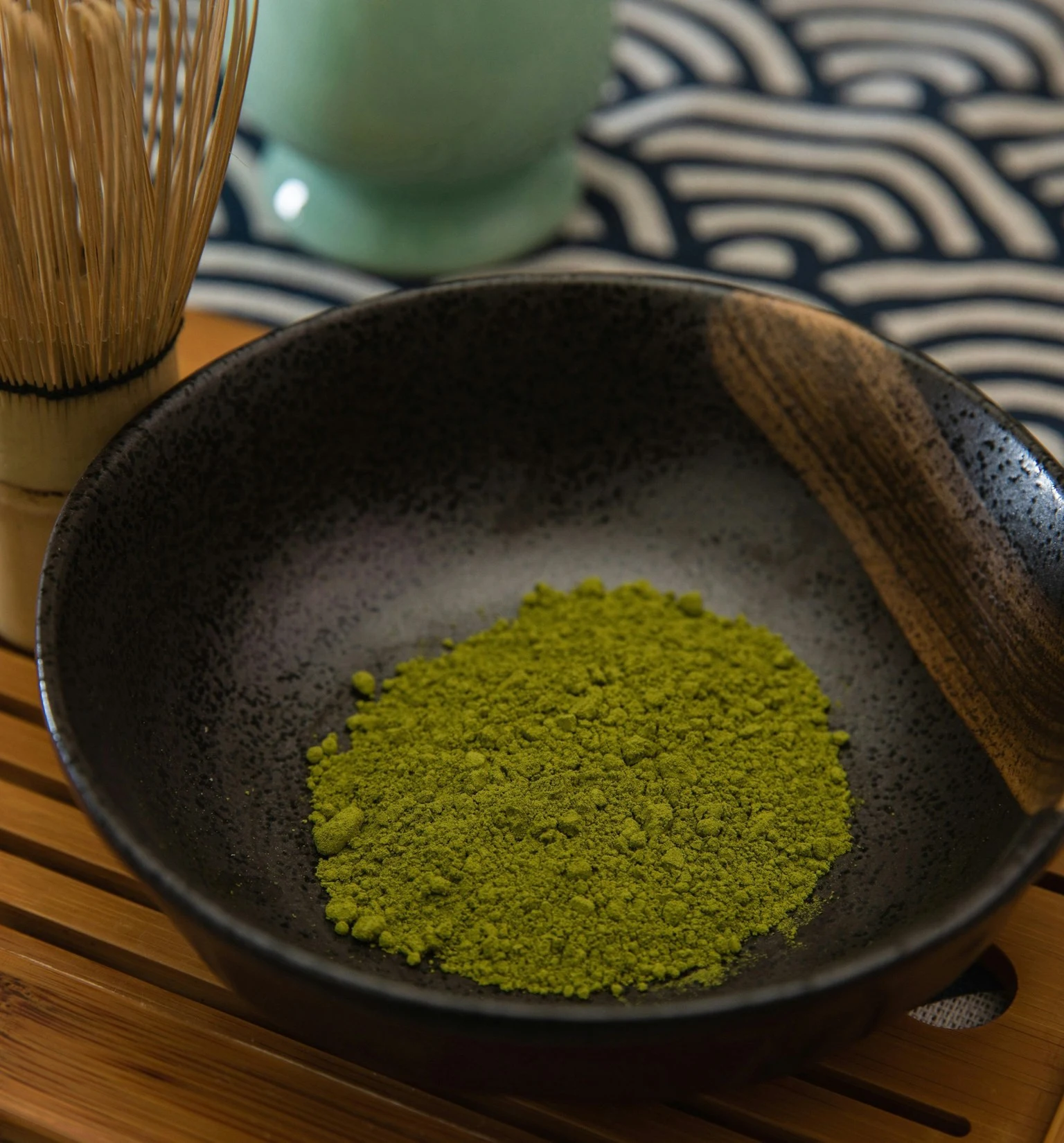 Japanese matcha powder in a bowl with a bamboo whisk — illustrative image